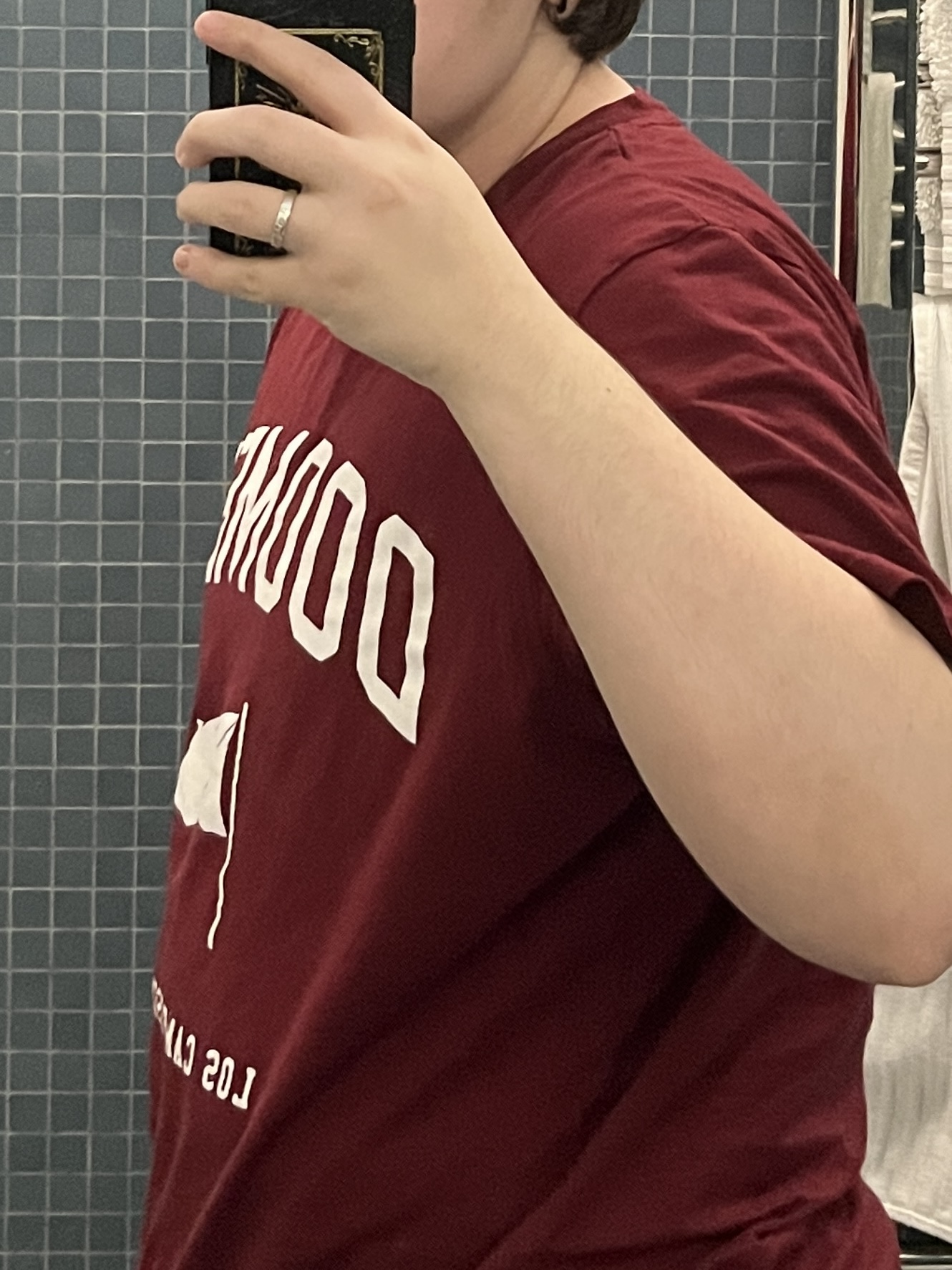Trans man wearing a red shirt facing sideways